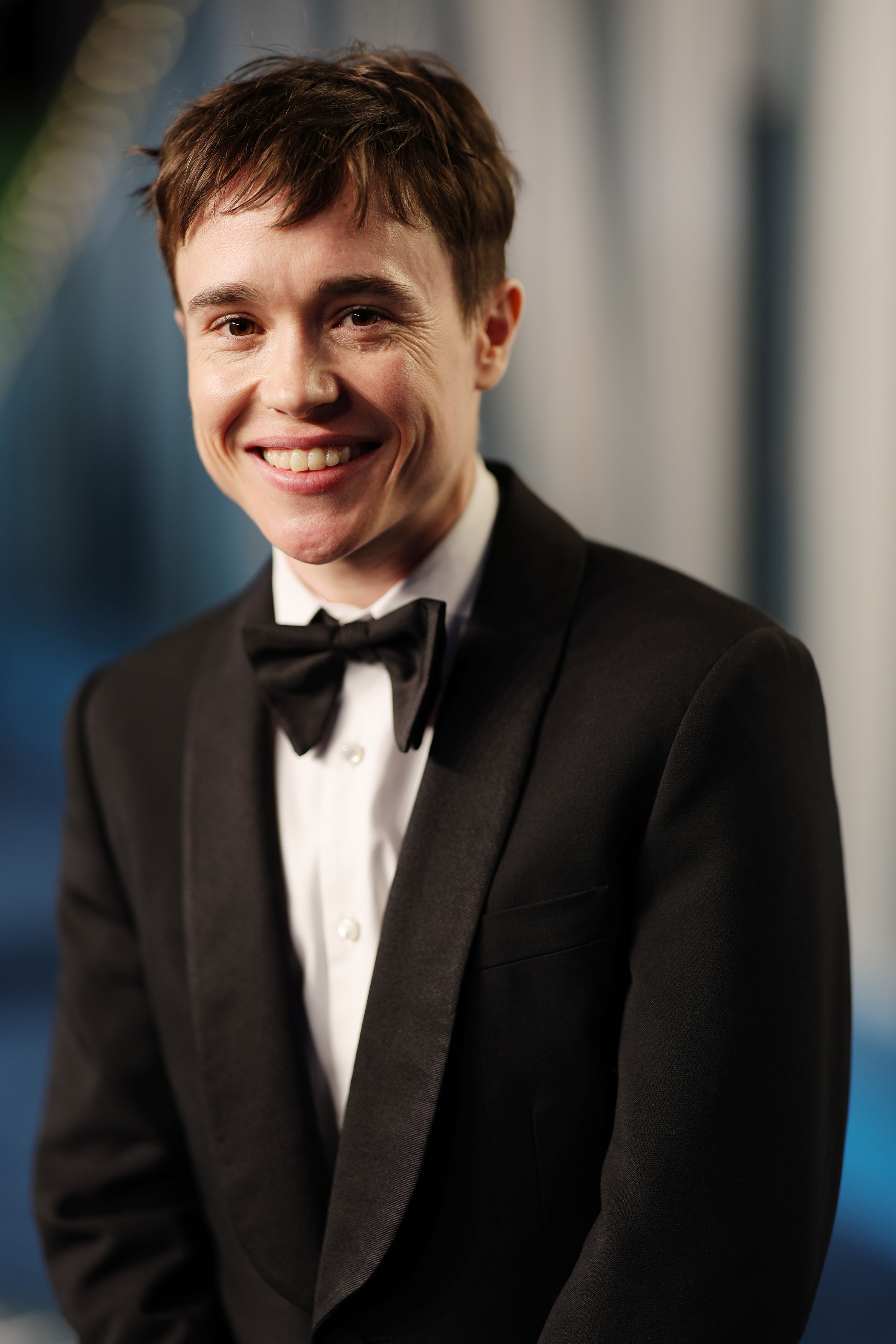 Close-up of Elliot smiling in a suit and tie