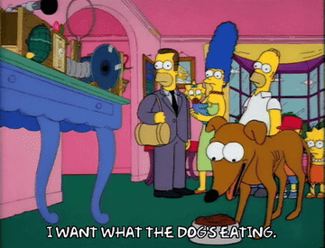 A dog eating while characters from &quot;The Simpson&#x27;s&quot; watch with the caption &quot;I want what the dog&#x27;s eating,&quot;