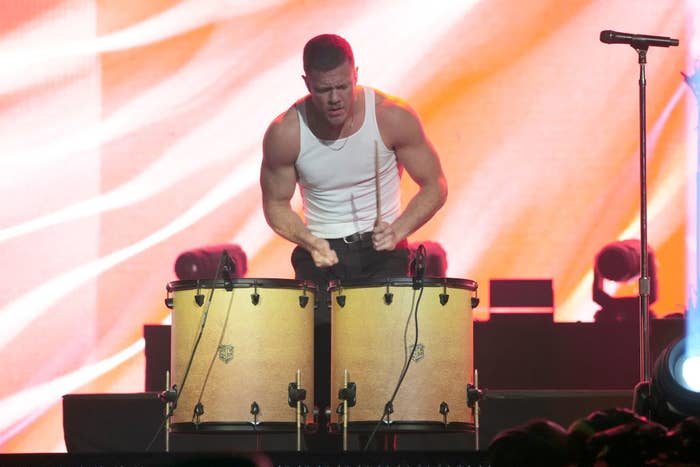 The lead singer of Imagine Dragons playing bongos onstage