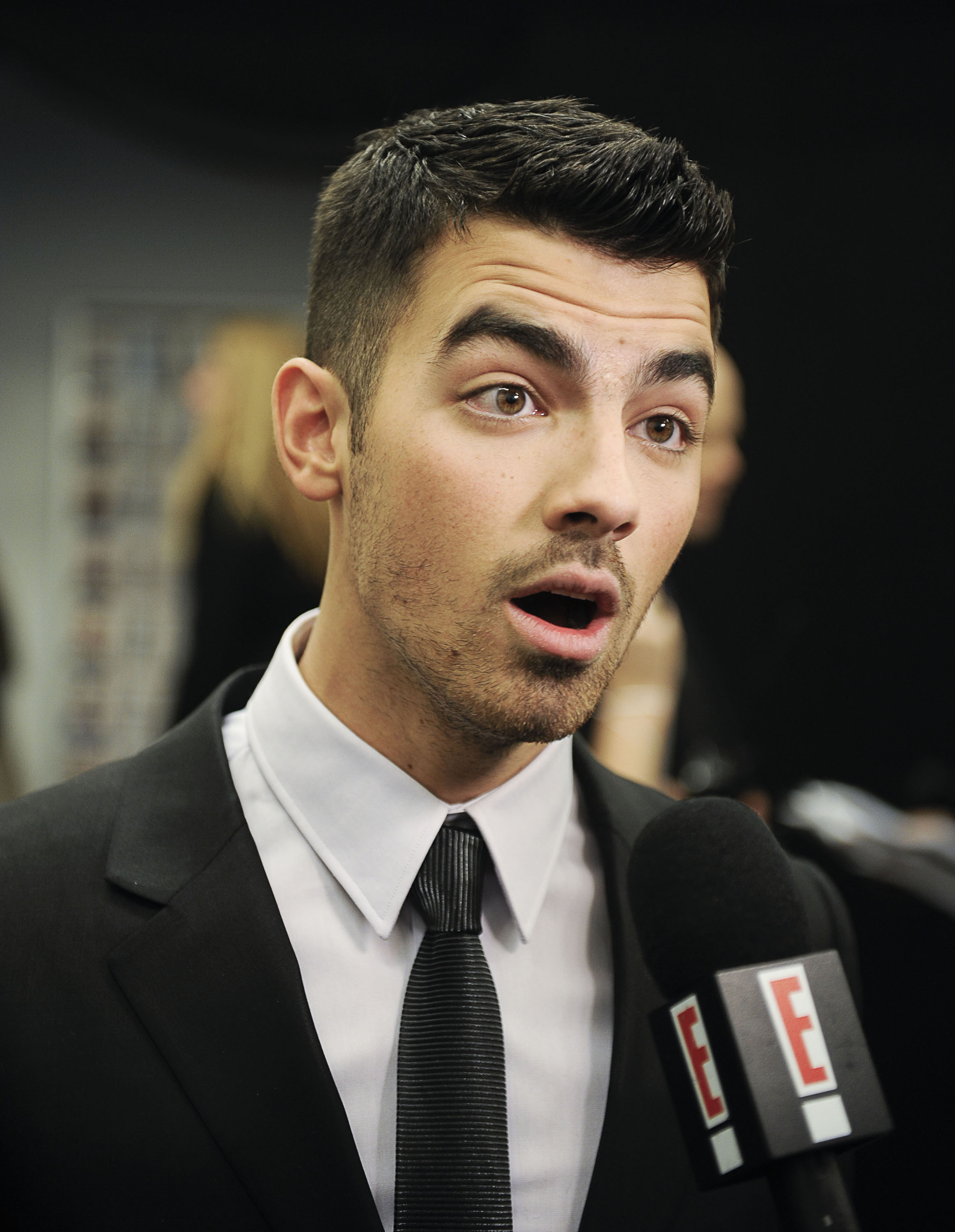 Joe in a suit and tie being interviewed