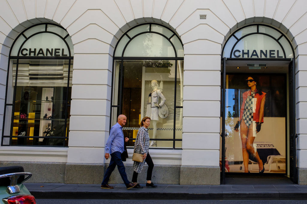 People walking by a Chanel window display