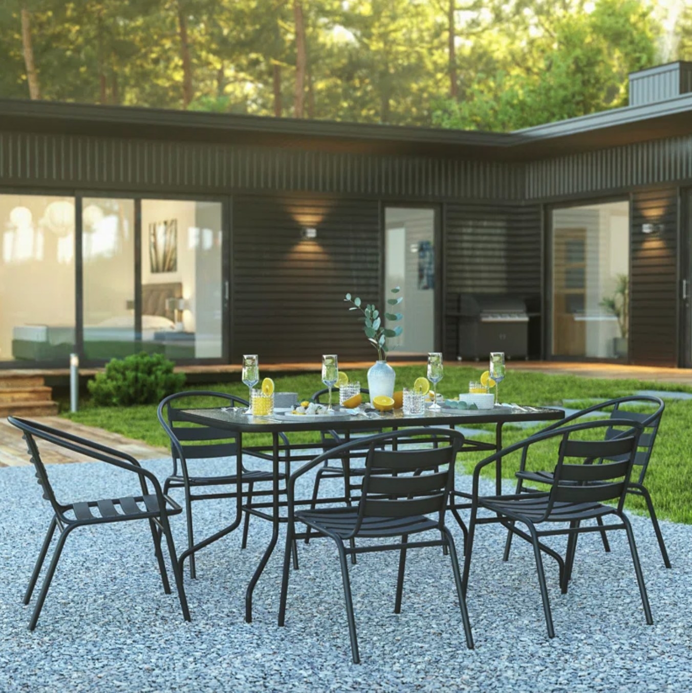 the black metal chairs and glass topped table in a decorated outdoor space