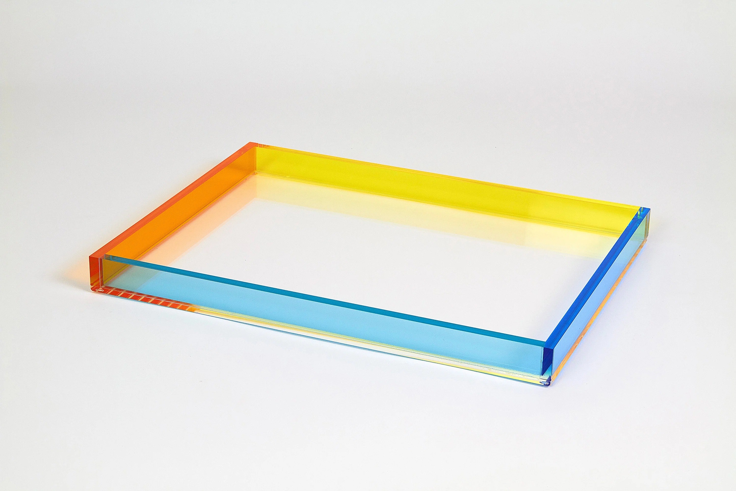 Transparent, rectangular tray with yellow, blue, and orange edges