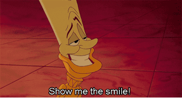 a gif of lumiere telling the beast to smile