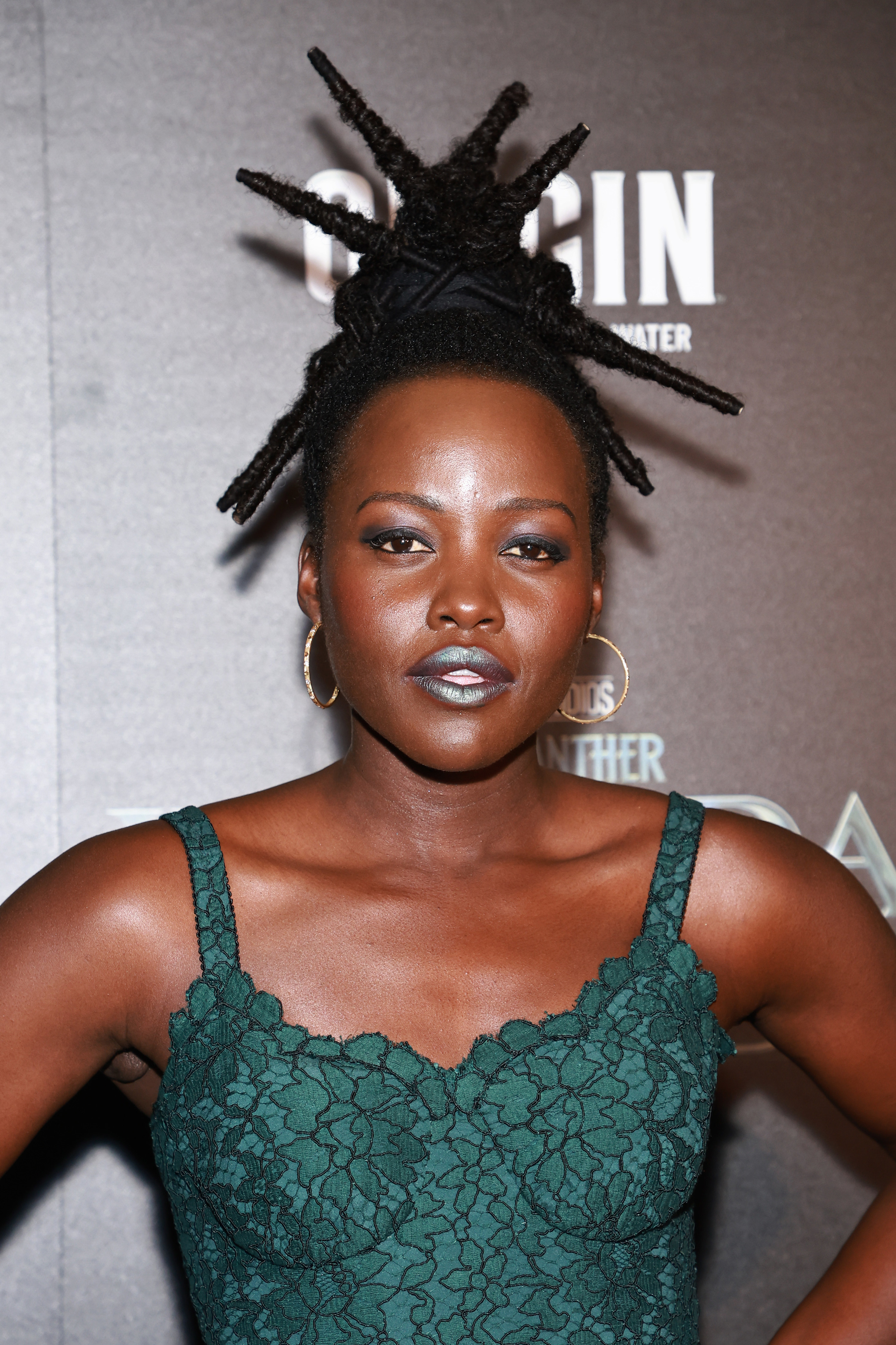 Lupita at a an event with her hair in an intricate spiked updo