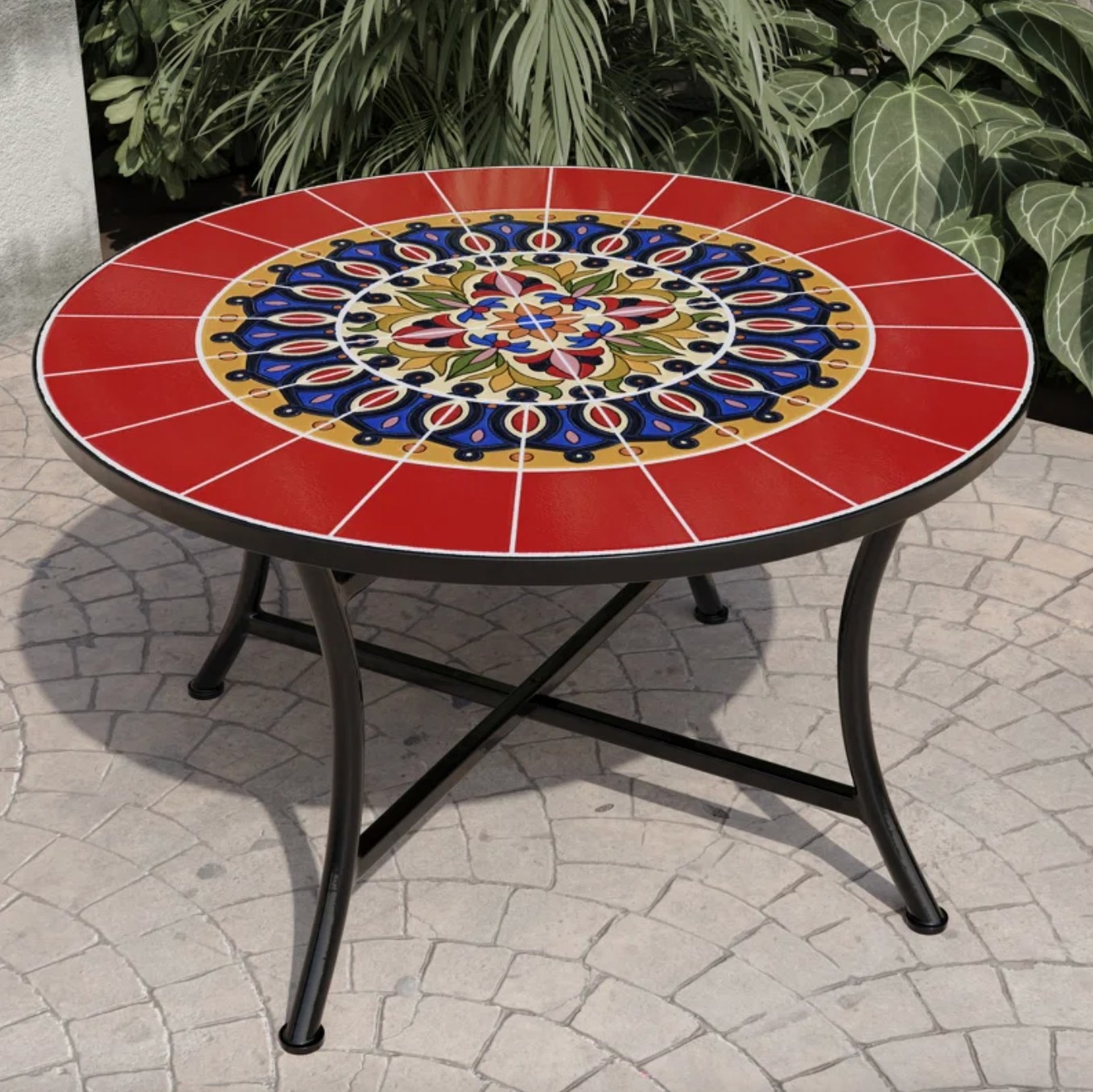 the red, blue and yellow mosaic topped coffee table on a patio