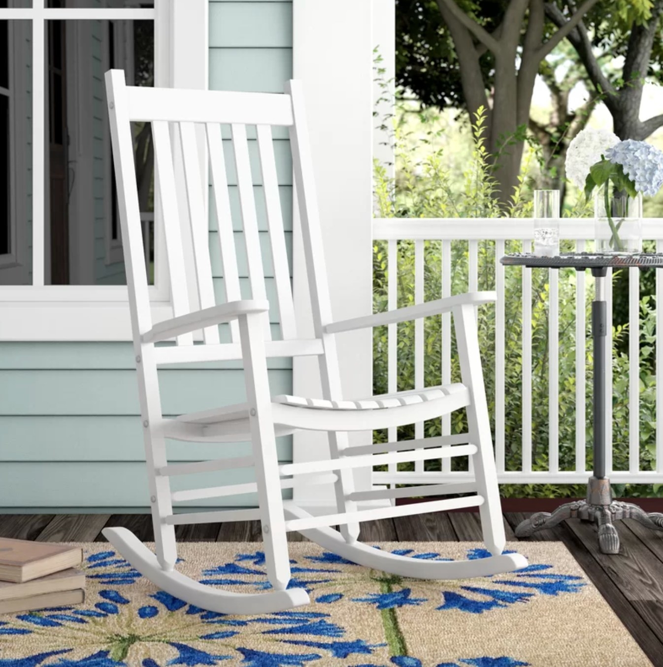 a white rocking chair in a decorated porch space