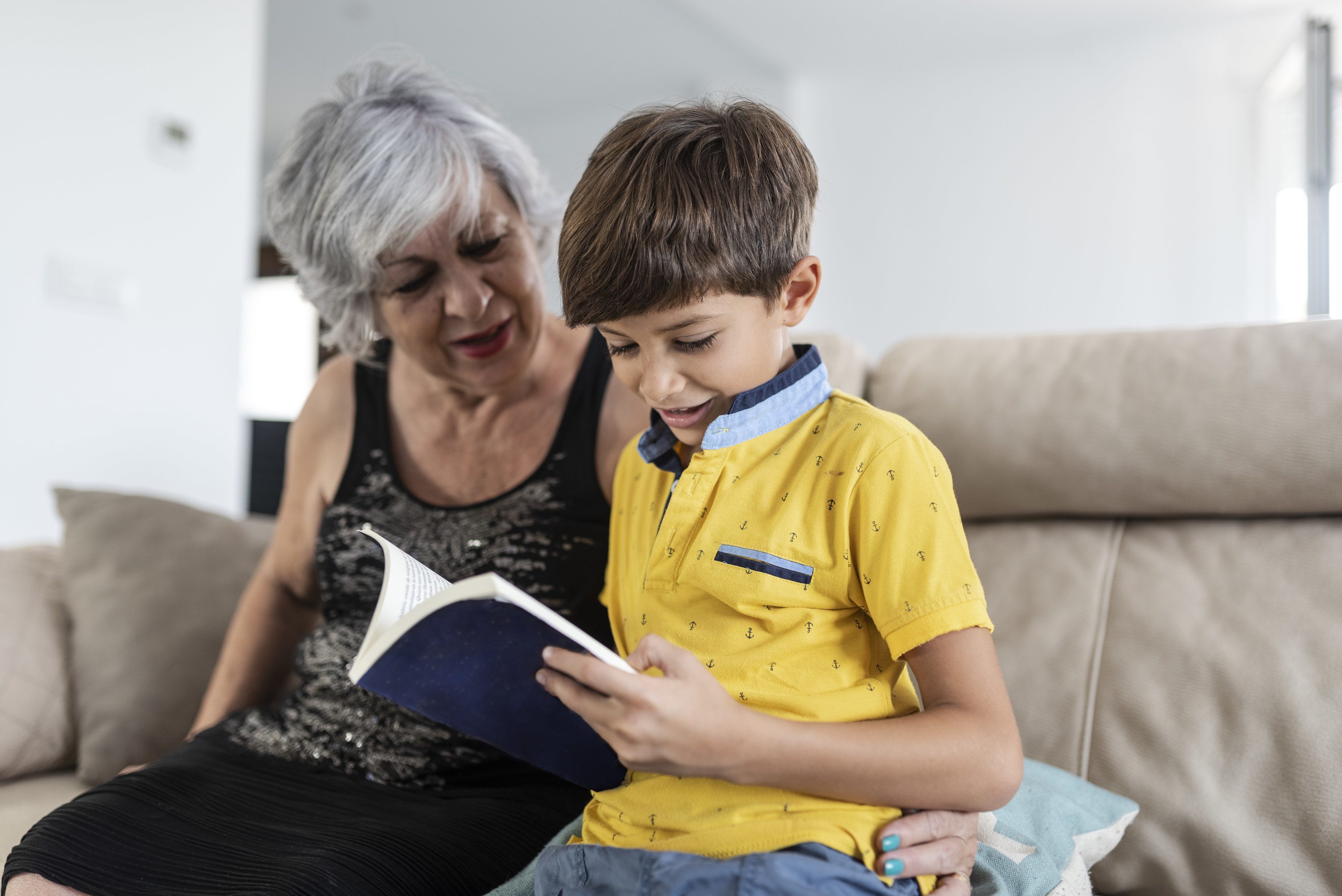 Little boy reading to his grandma
