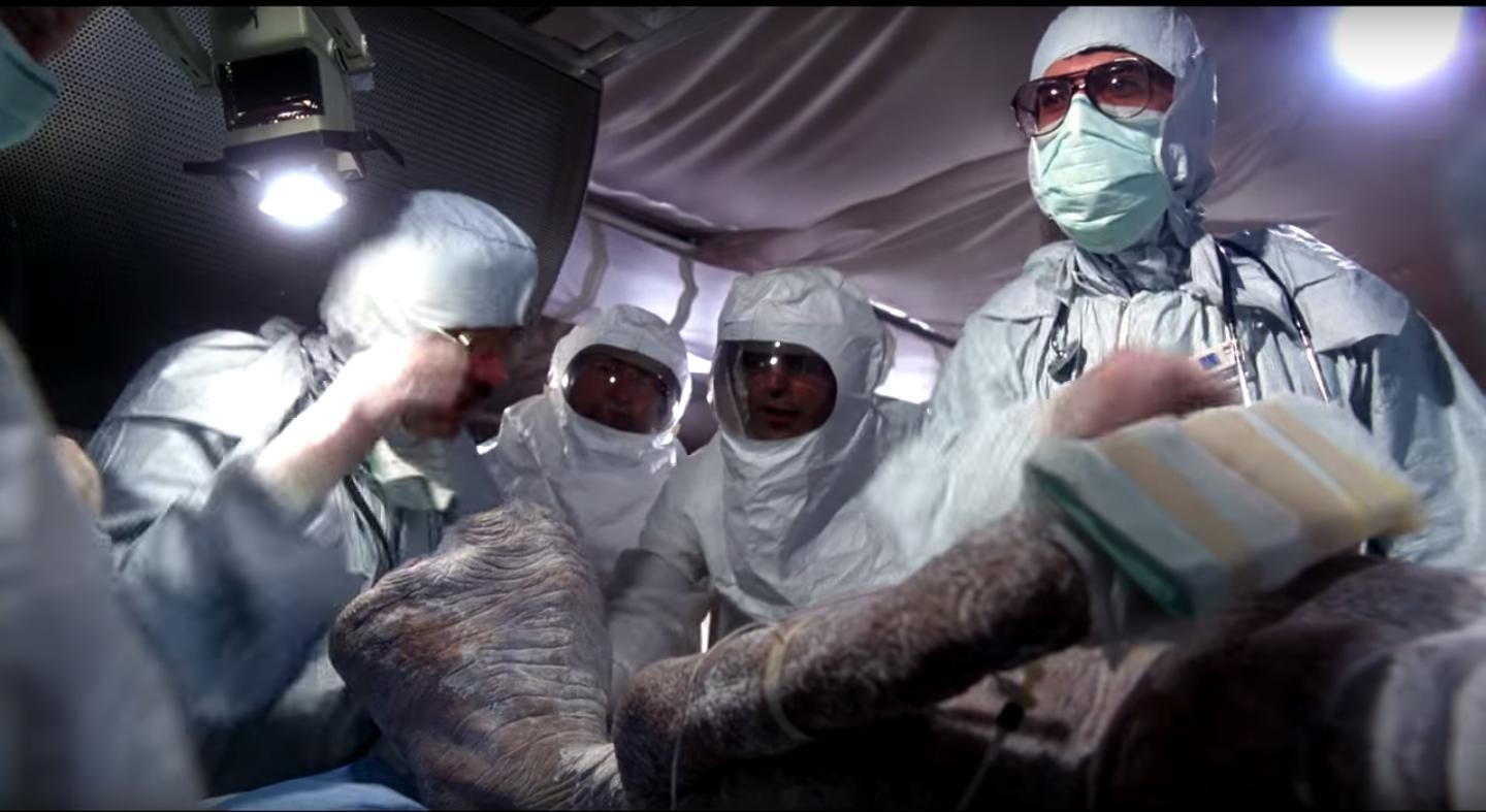 people wearing hazmat suits as they look at e.t.
