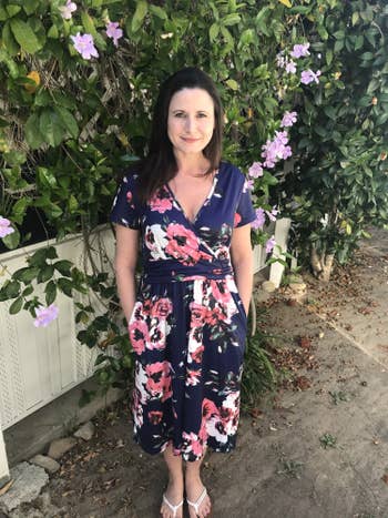 Reviewer standing in the blue and floral dress