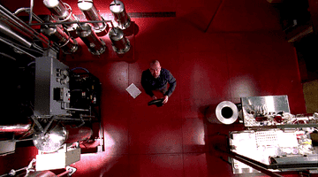 A bald man throws a shoe at a ceiling