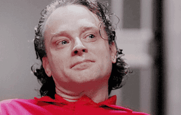 Brad Dourif stares intensely with tears welling in his eyes
