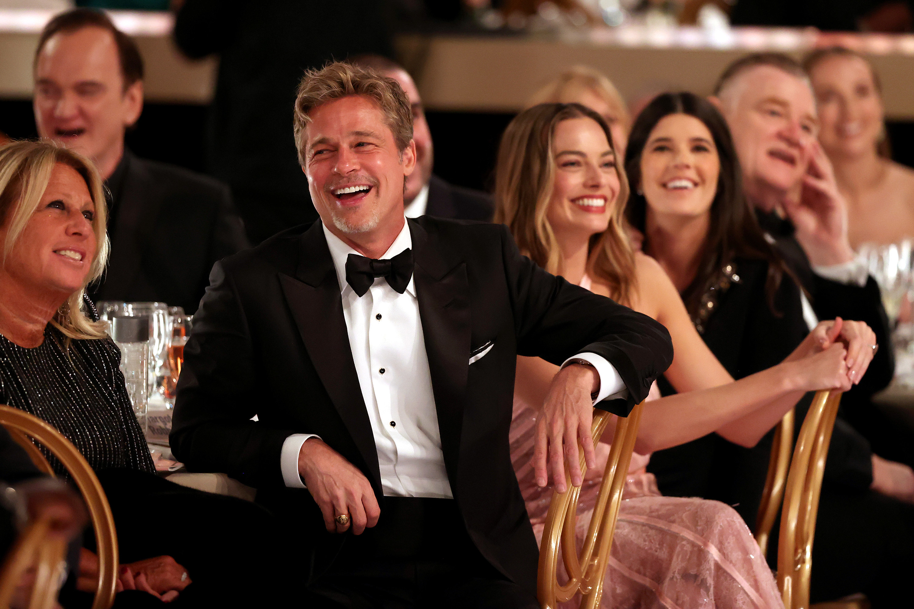 Brad wearing a bow tie in the awards show audience laughing