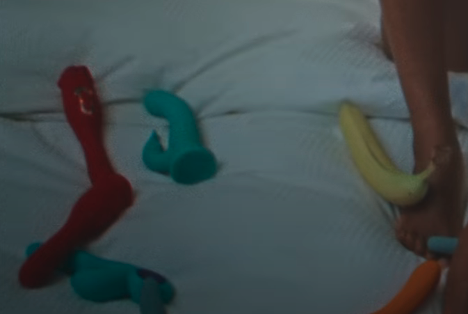 Several sex toys and a banana on a bed