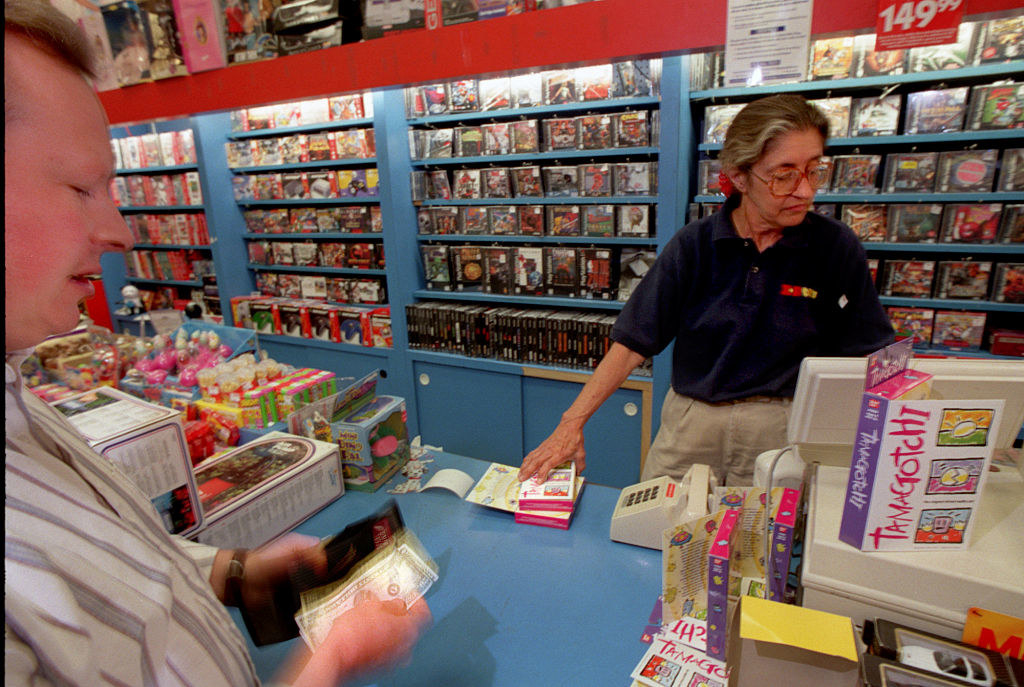 A cashier at the KB Toys cash register helping someone