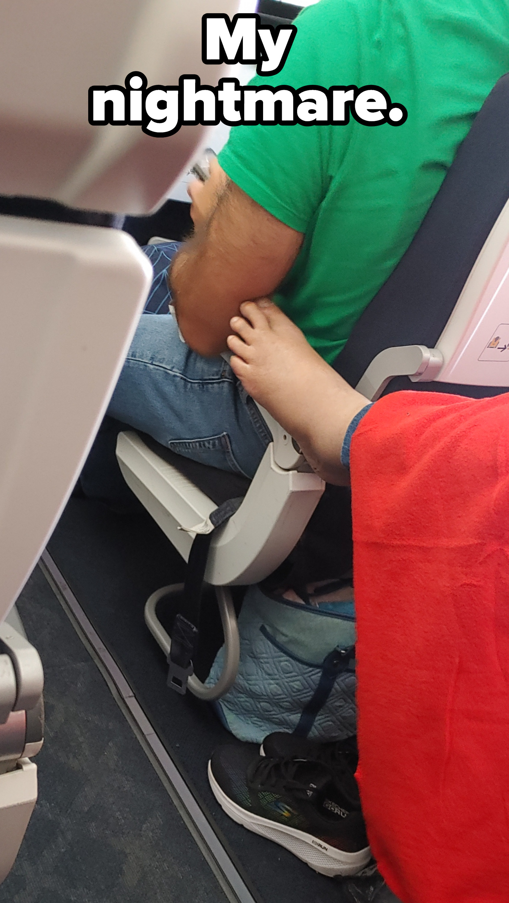 A person&#x27;s foot touching someone&#x27;s arm on a plane