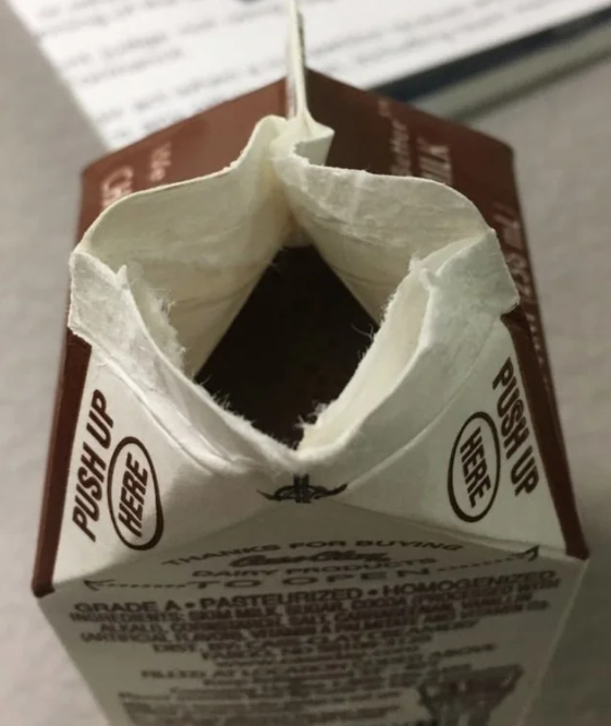 Badly opened carton of milk