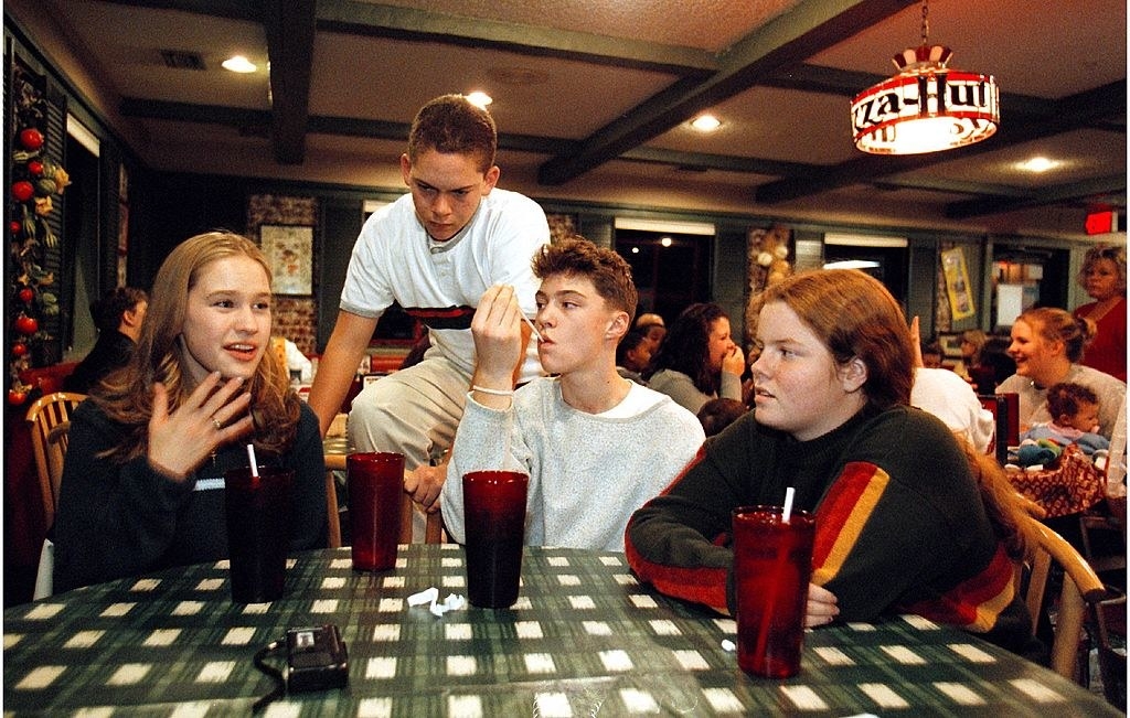 Teenagers at a Pizza Hut table with a checkered tablecloth