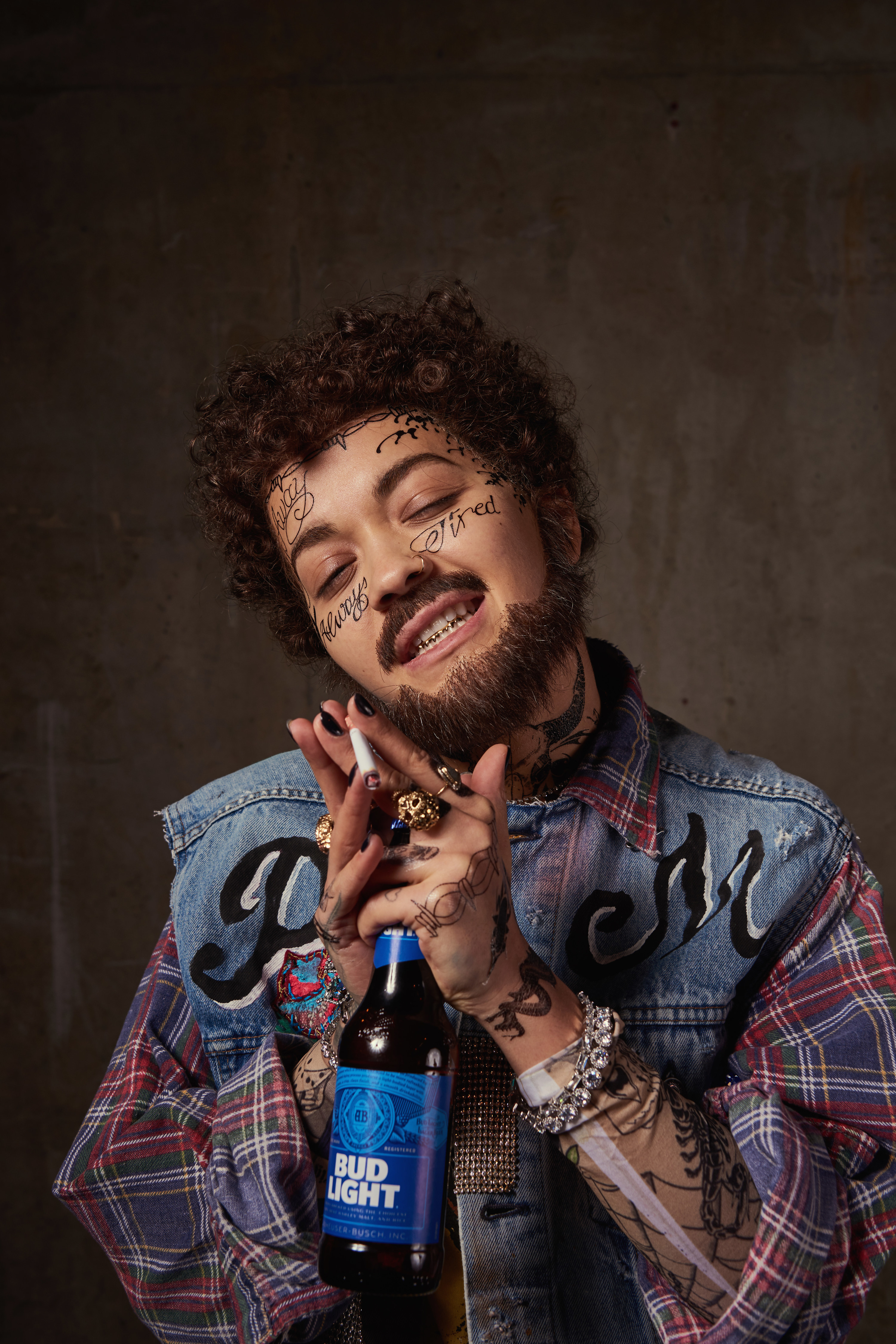 for a bud light ad dressed as a man wearing a denim veset and flannel shirt with tattoos