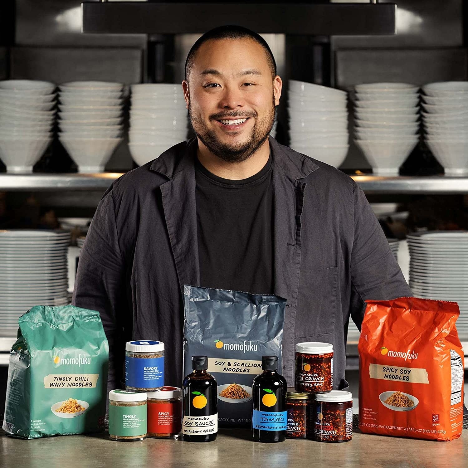 Chef David Chang standing behind various Momofoku products.