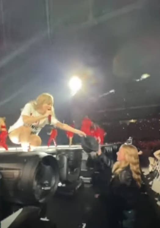 Taylor Swift handing a fan a hat