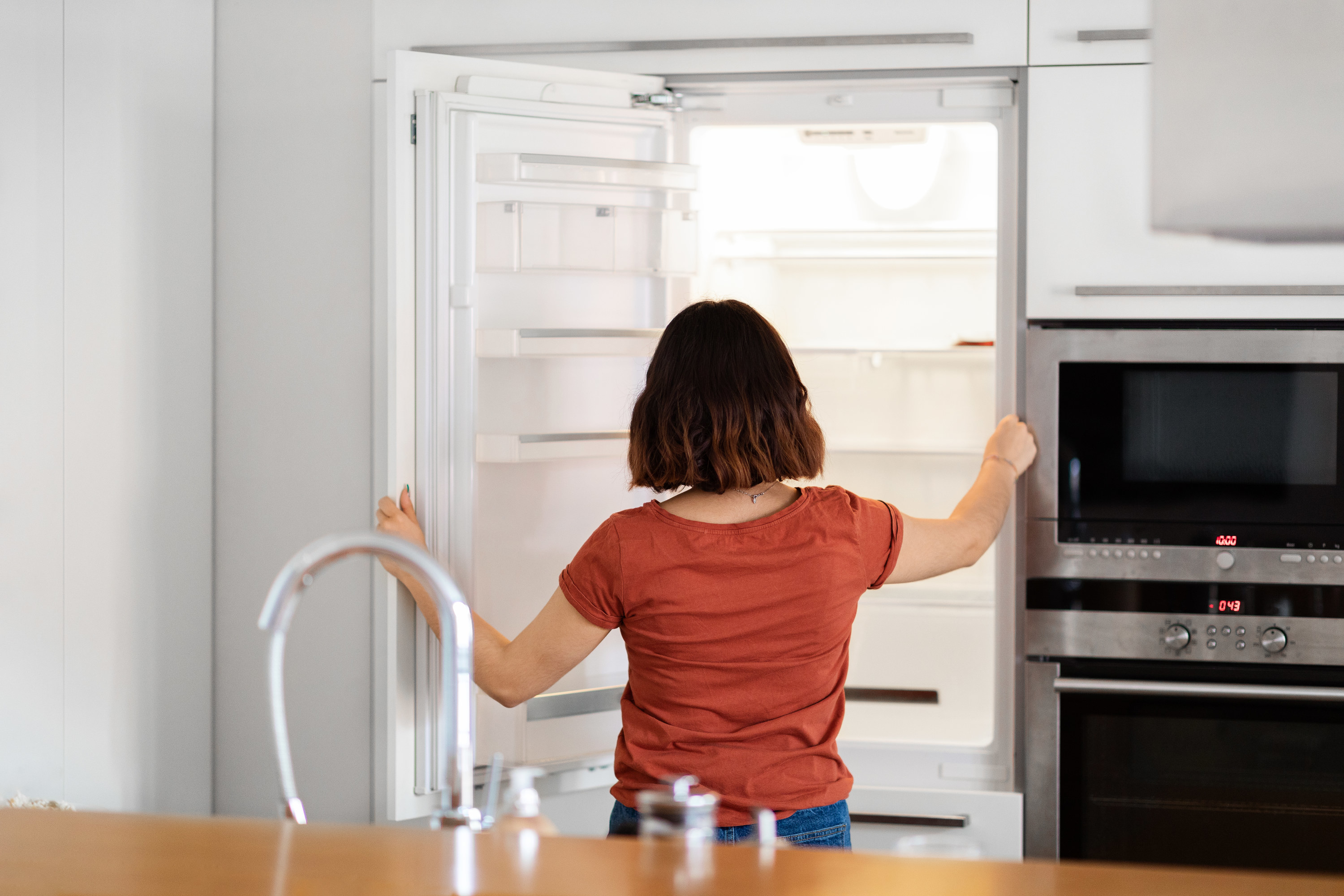 Woman staring into empty fridge