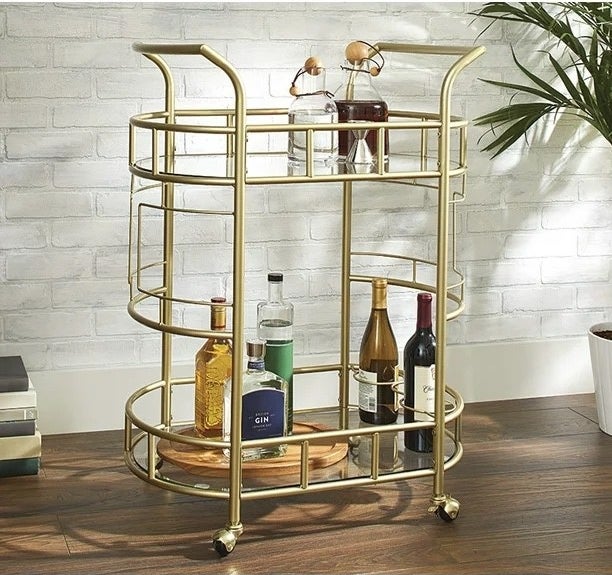 gold bar cart with bottles on it