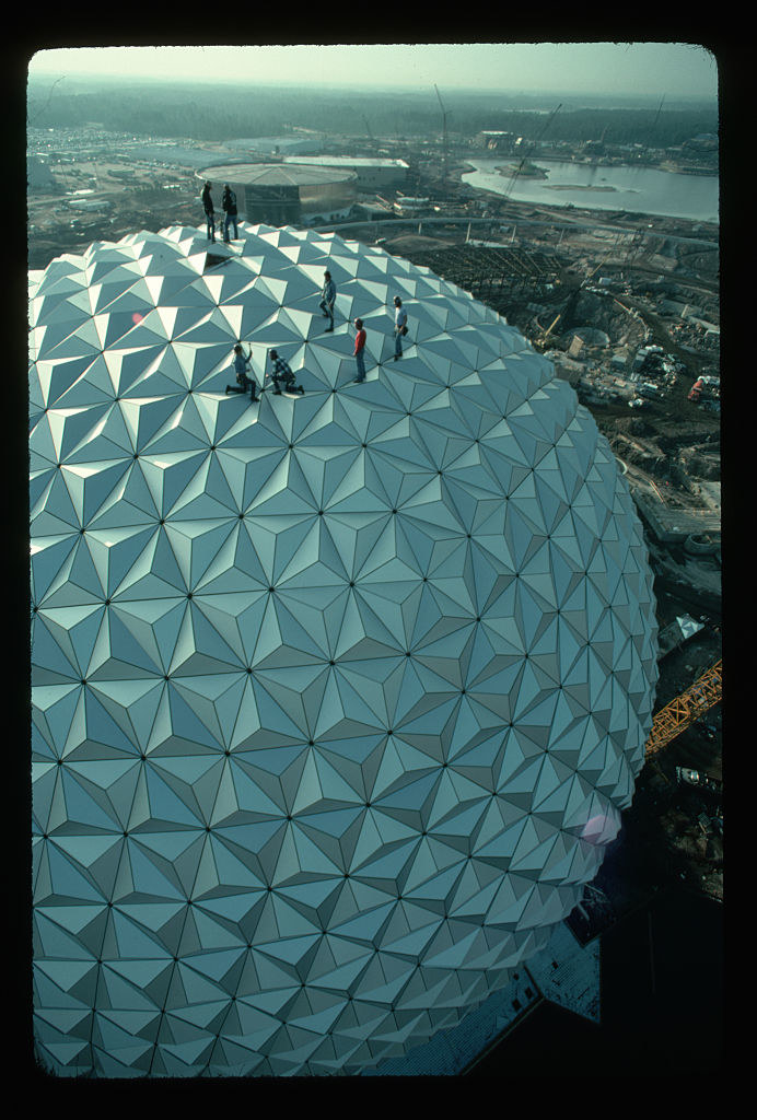 Construction workers standing on a spherical outdoor edifice