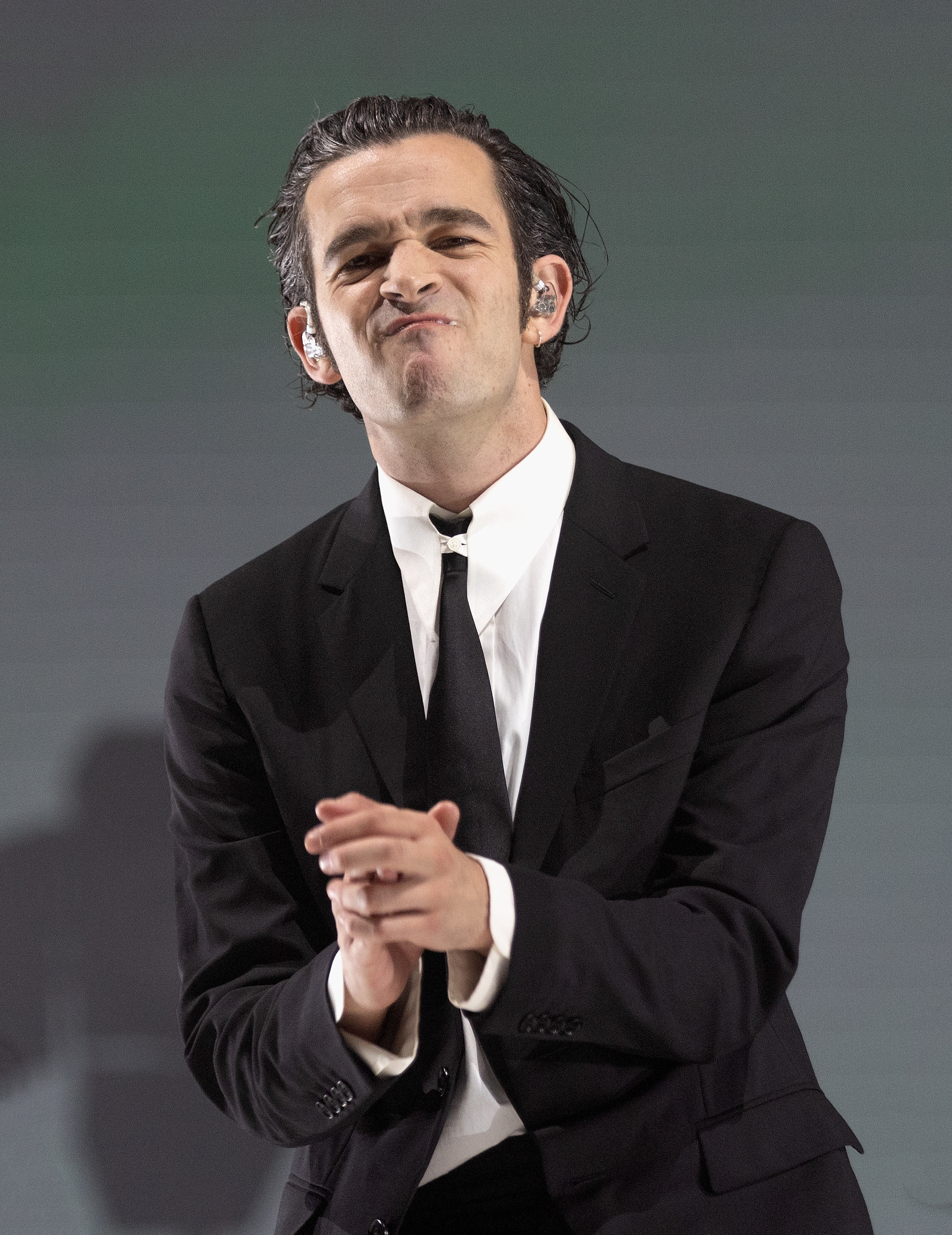 Matty in a suit and tie with his hands together