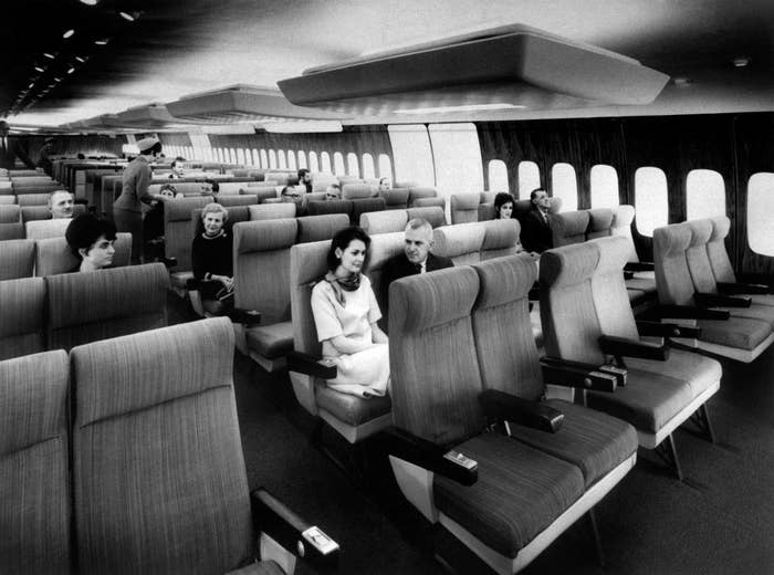 A very wide plane interior with two aisles and rows of four comfy-looking seats in the center and two or three seats on the side