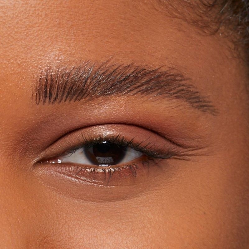 A person showing a sculpted eyebrow with fluffy eyelashes