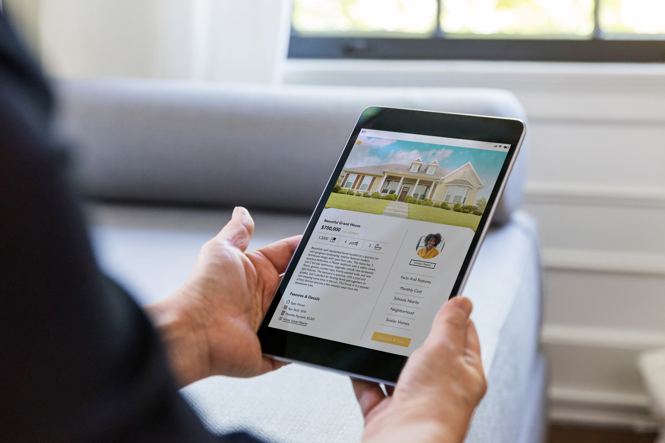 A person reads a house listing on a tablet