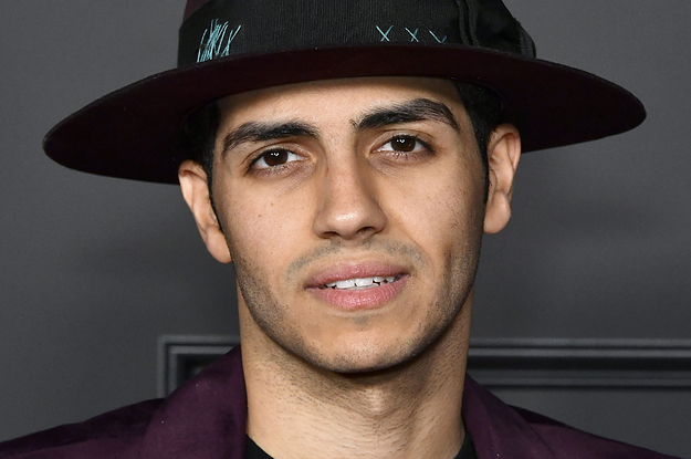 Mena Massoud poses for a photo on the red carpet
