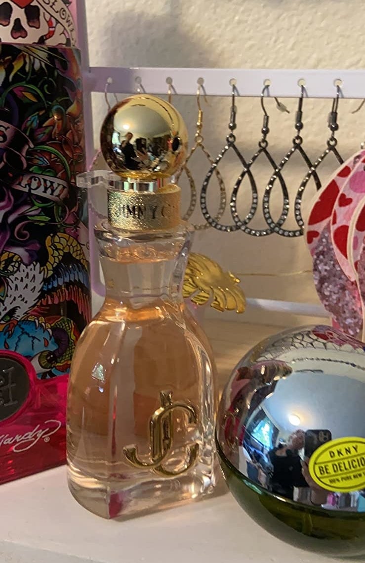 A yellow and white bottle of perfume on a reviewer&#x27;s shelf