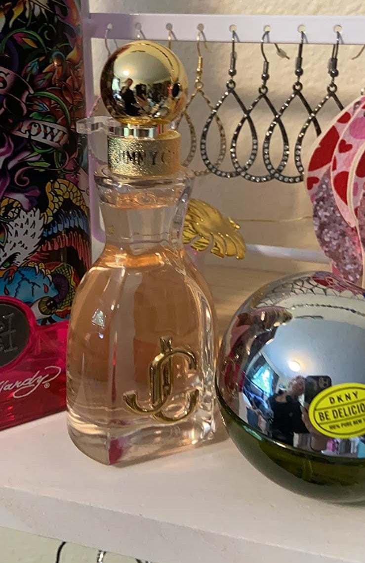 A yellow and white bottle of perfume on a reviewer&#x27;s shelf