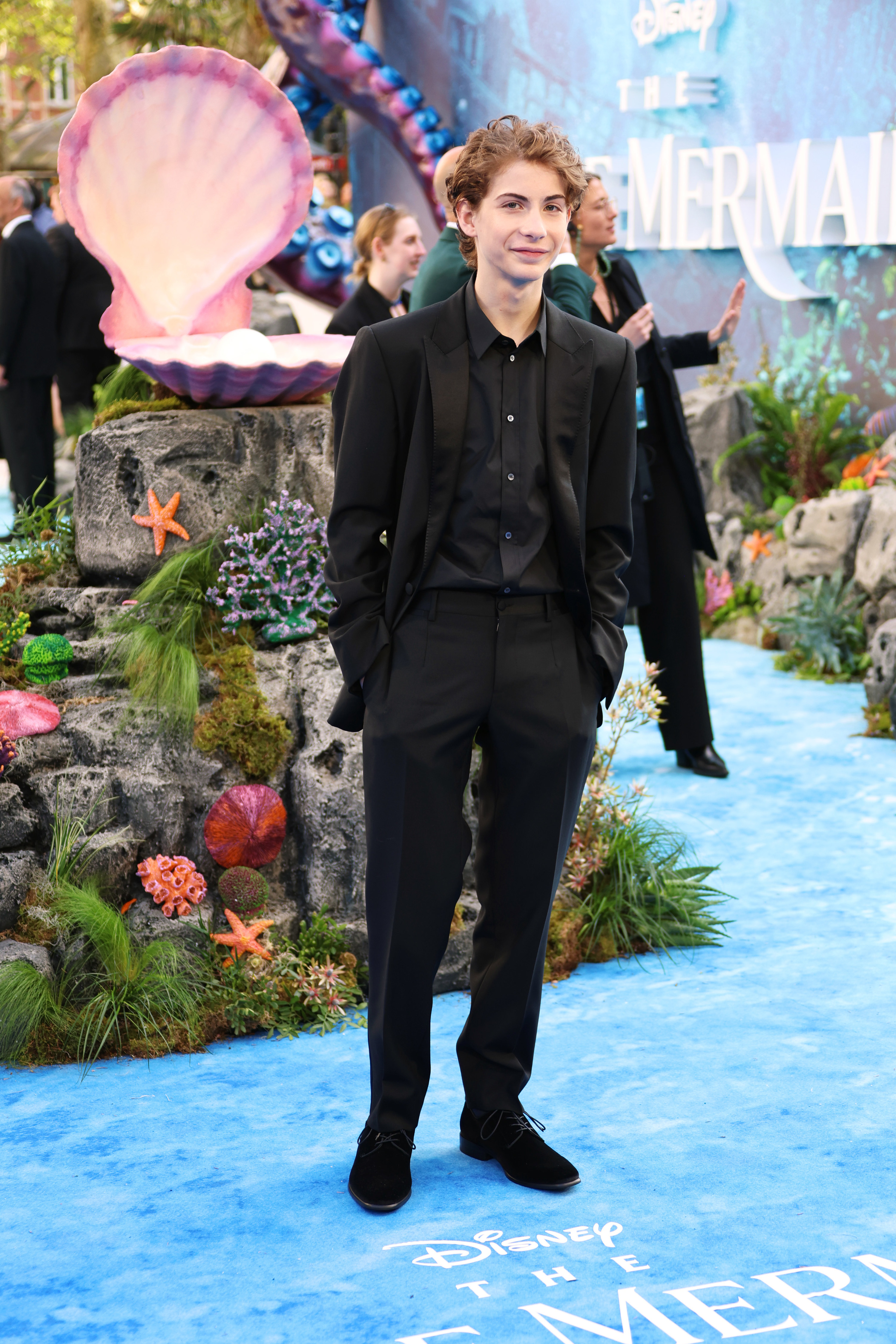 jacob tremblay poses on a red carpet