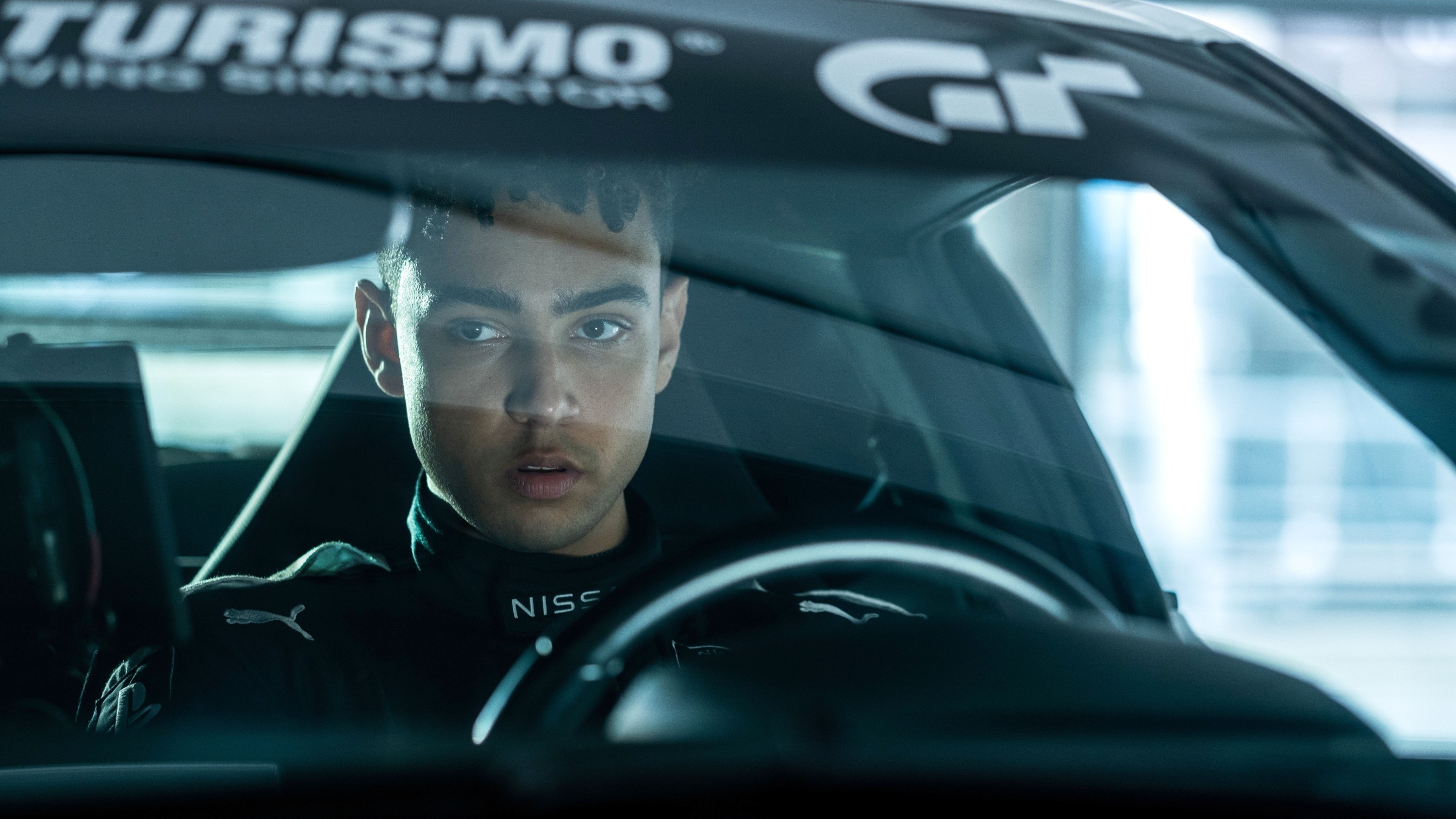 A man sits in the driver&#x27;s seat of a race car