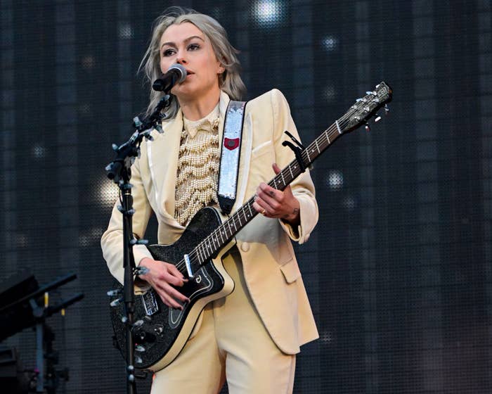 Phoebe playing the guitar and singing onstage