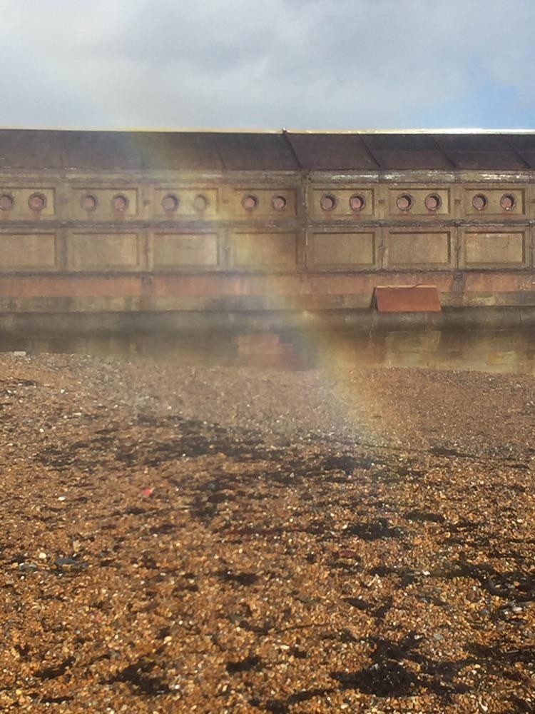 a rainbow ending in some dirt on the ground