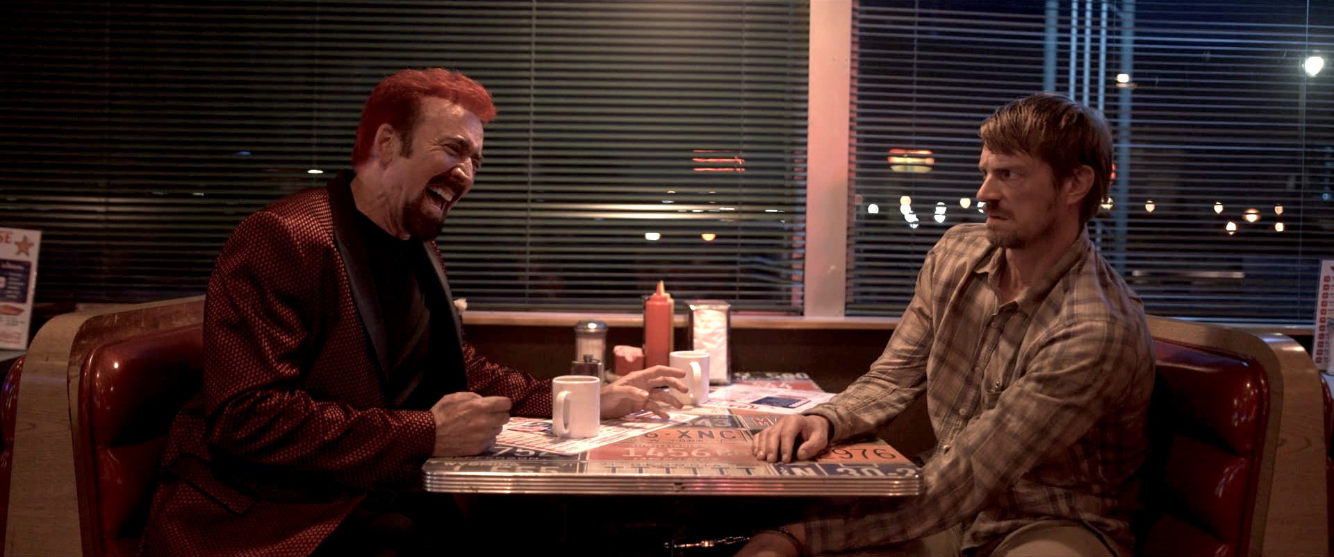 Two men talk at a diner table