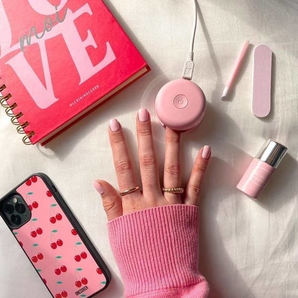 someone giving themselves a gel manicure with the pink set