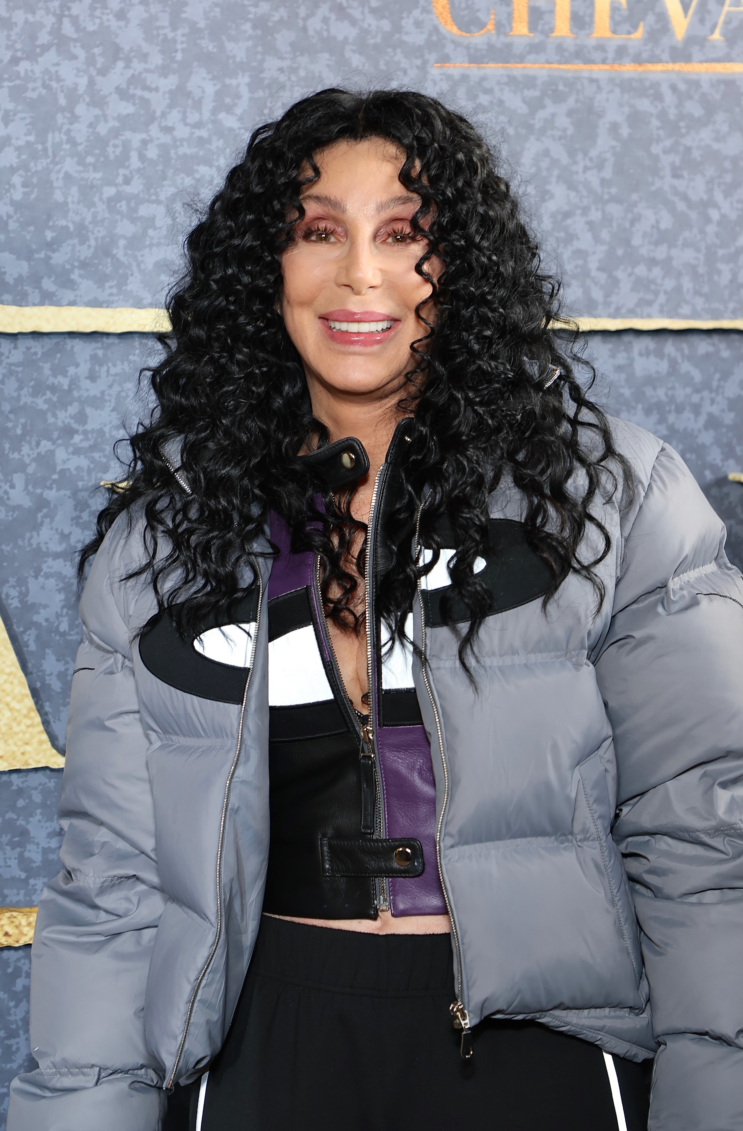 closeup of her in a puff jacket and long curly hair