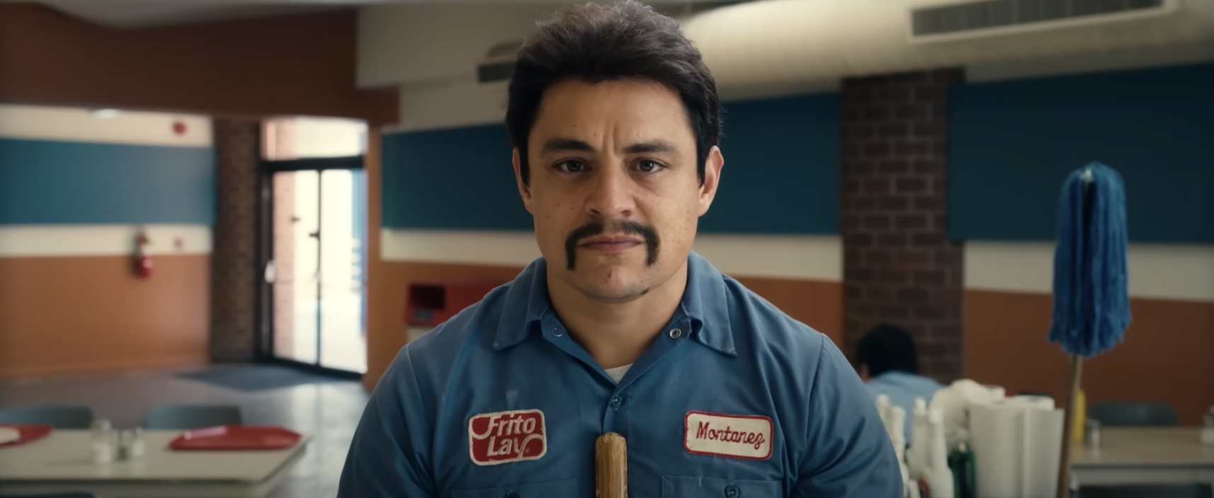 A man in a &quot;Frito Lay&quot; uniform sweeps the floor