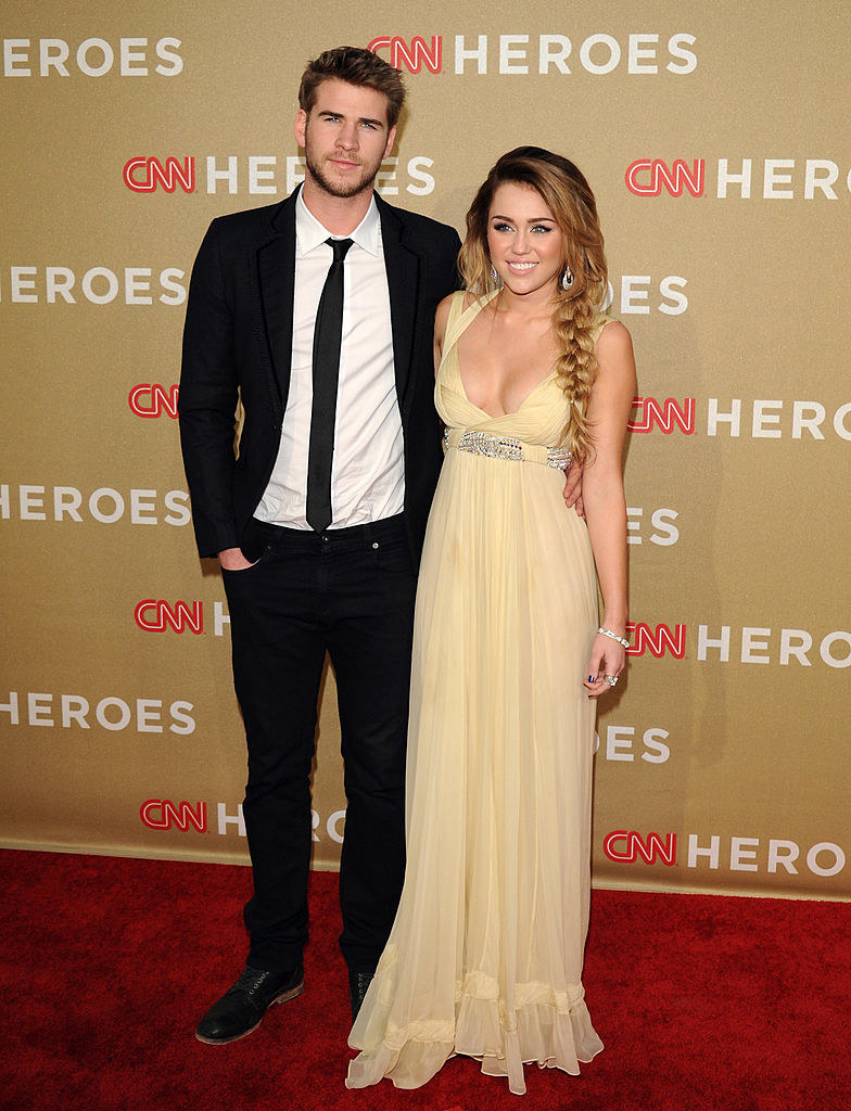 with liam hemsworth wearing a long dress and hair in a long side braid