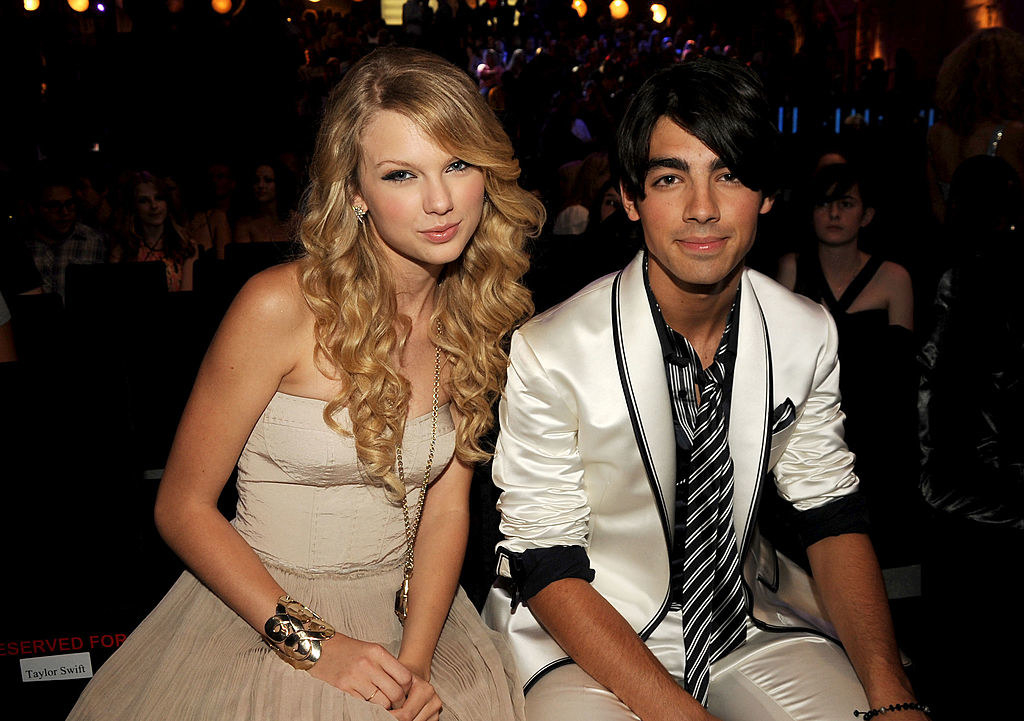 with long curly hair and a strapless dress with joe jonas