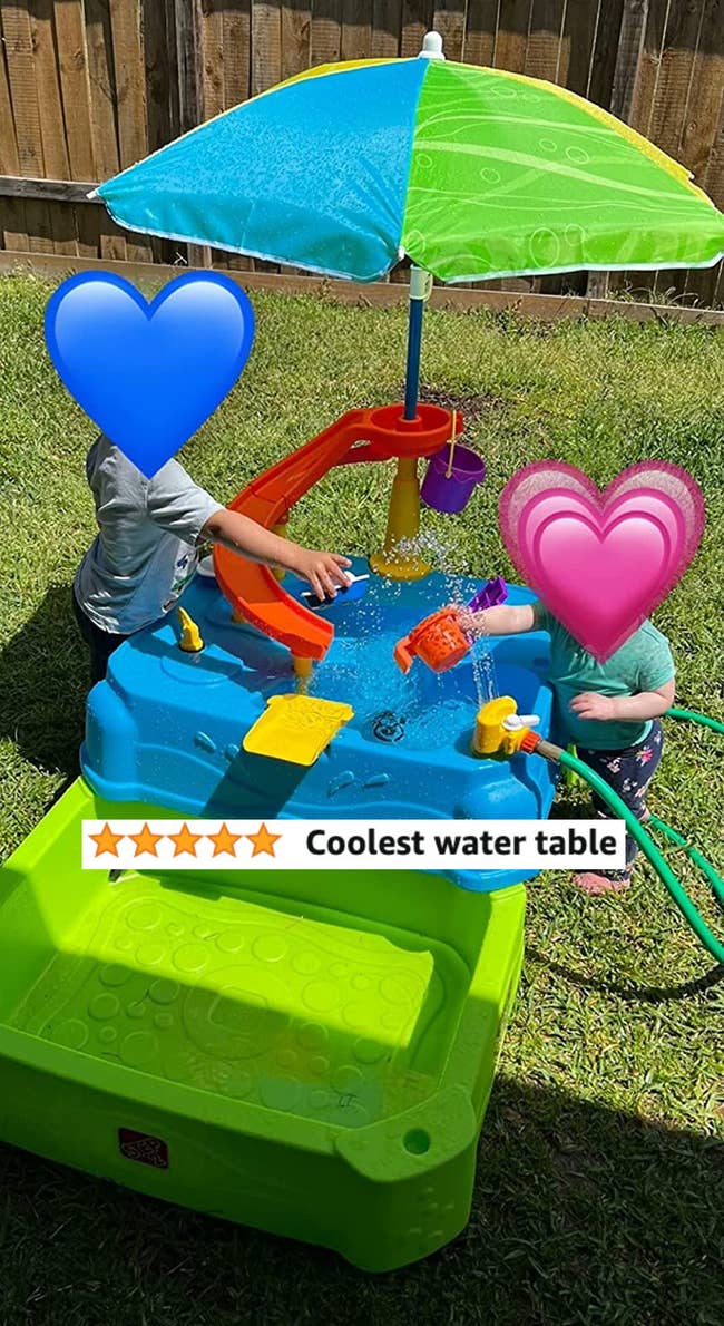 Two children playing with the water table