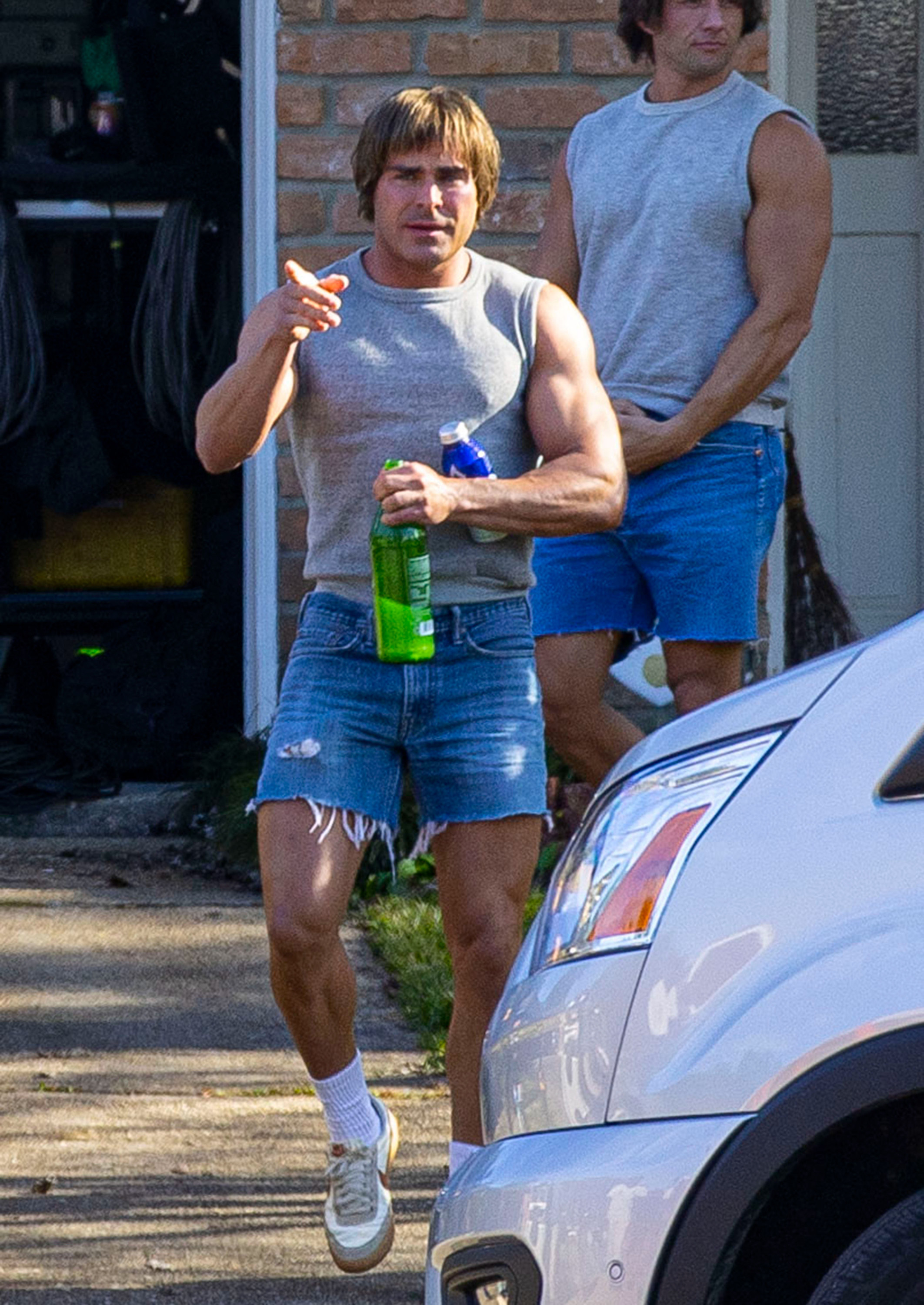 zac in cut off shorts and cut off shirt with a long grown out bowl cut
