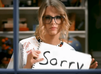 her holding up a notebook that says sorry
