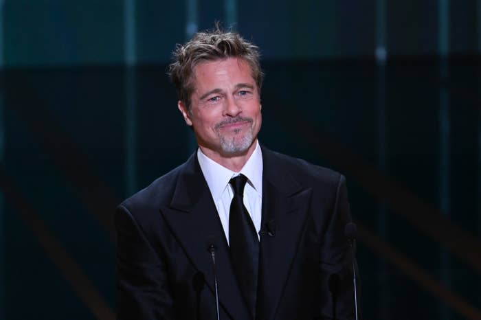 A closeup of Brad Pitt in a suit and tie on stage