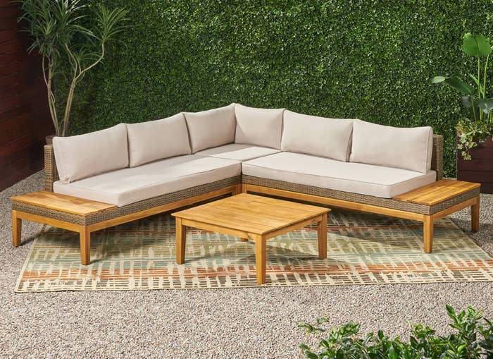 An outdoor sofa and table is shown in a glamorous backyard